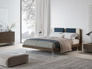 Letto matrimoniale in nobilitato finitura Forestal Dark con testiera rivestita da due cuscini imbottiti in tessuto e piedini trasparenti Ginevra GL14 di Marka Total Living