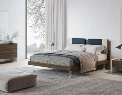 Letto matrimoniale in nobilitato finitura Forestal Dark con testiera rivestita da due cuscini imbottiti in tessuto e piedini trasparenti Ginevra GL14 di Marka Total Living